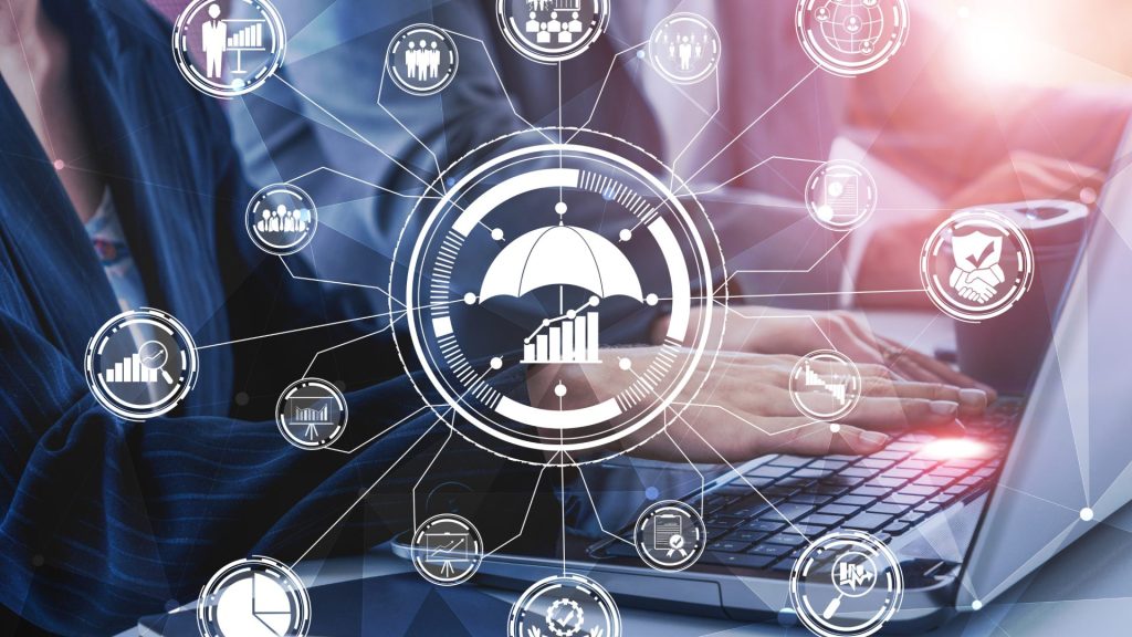 Deux professionnels analysent des graphiques financiers sur un ordinateur portable, discutant de l'évaluation d'entreprise.